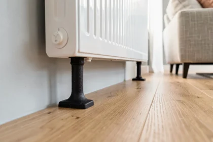 Pied en fonte noir pour radiateur posé sur parquet stratifié en chêne clair dans un salon scandinave